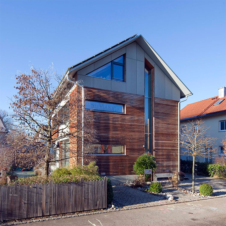 Ein modernes Passivhaus mit Holzfassade steht in einer ruhigen Straße in Fürstenfeldbruck.