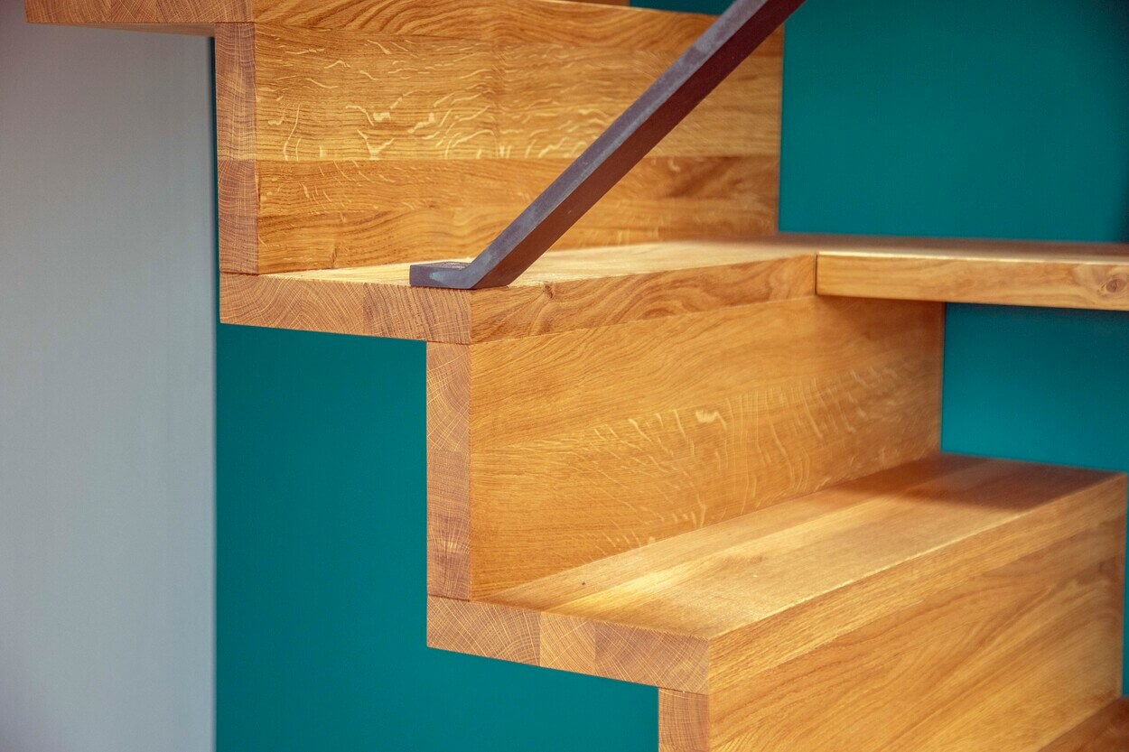 Detail einer modernen Holztreppe mit klaren Linien in einem Gebäude in Dachau.