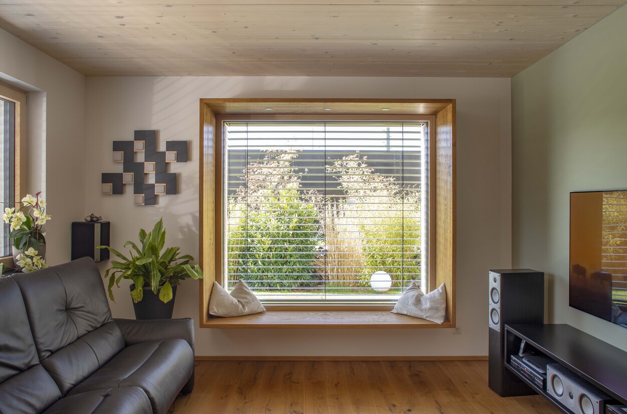 Ein gemütliches Wohnzimmer in Prien mit Ledersofa, großem Fenster und modernen Dekorationen lädt zum Entspannen ein.