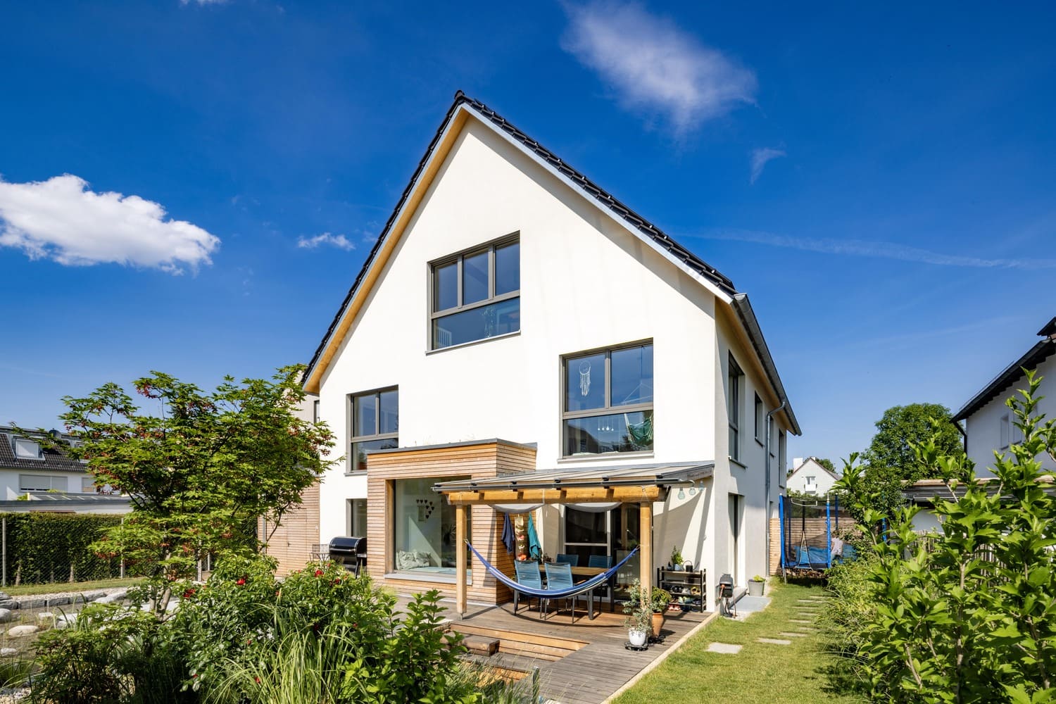 Mehrfamiliehaus, verputztes Holzhaus in München, Pergola