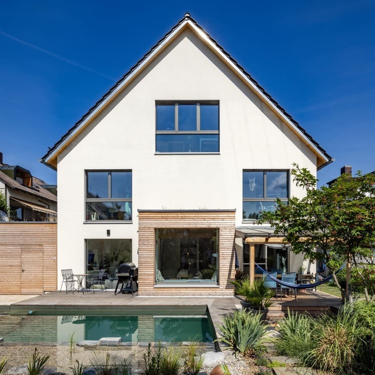 Mehrfamiliehaus, verputztes Holzhaus in München, Schwimmteich,