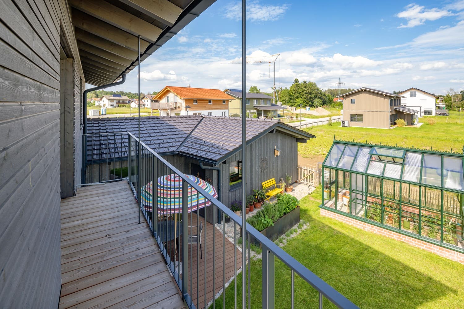 Balkon im OG mit Blick in Garten und auf Gewächshaus, Metallgeländer mit Streben