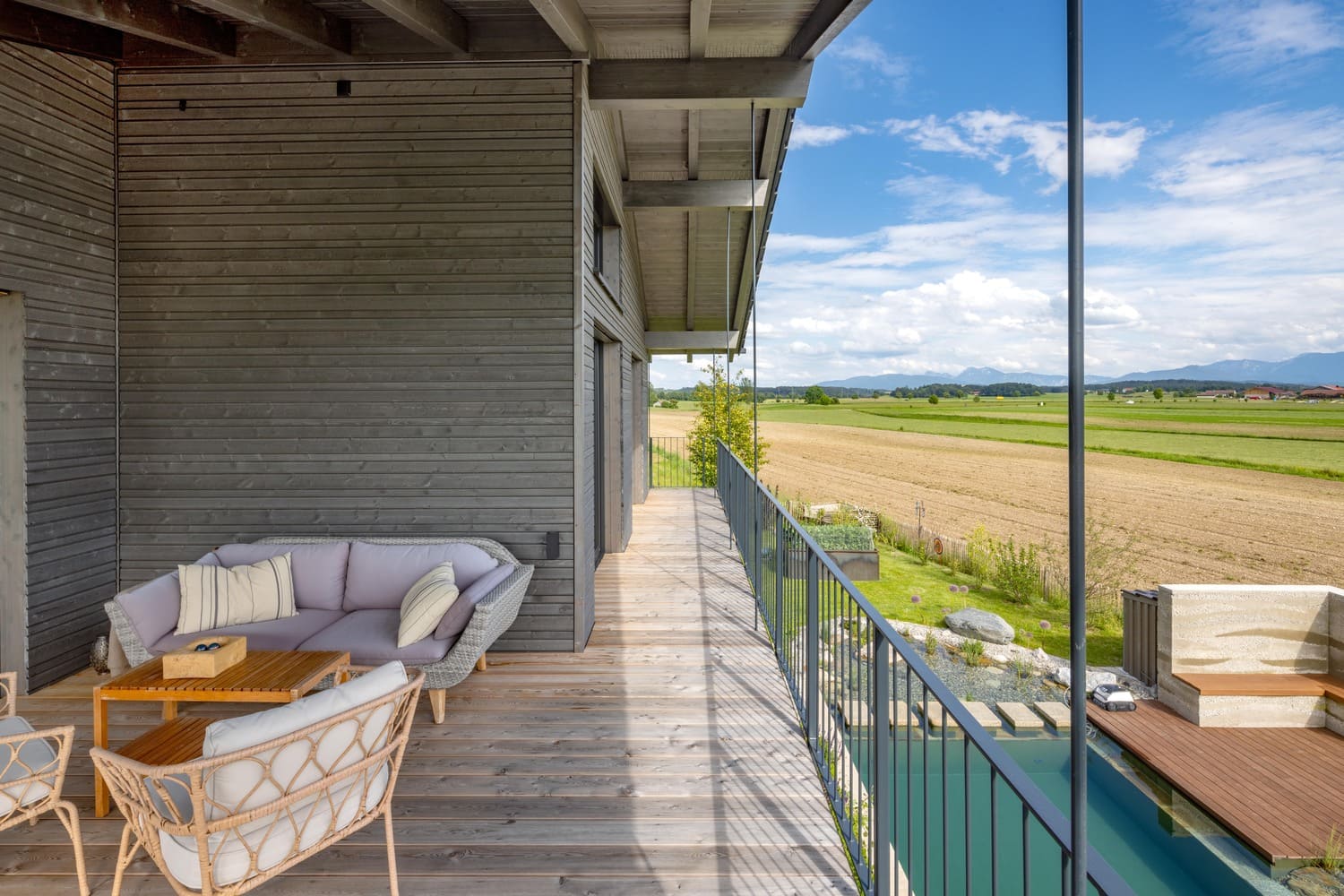 Freisitz im OG mit gut sichtbarer wunderschöner grauer Holzfassade und einem Bergblick
