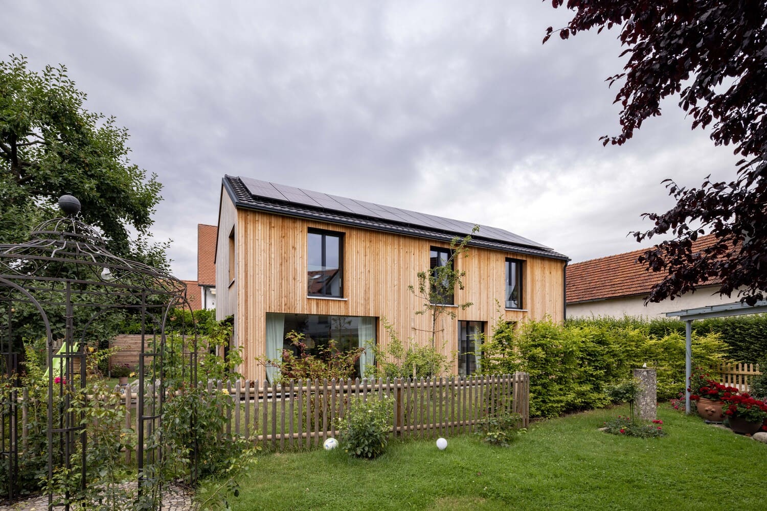 Holzhaus Zolling mit Holzfassade und bodentiefen fenstern im OG und EG