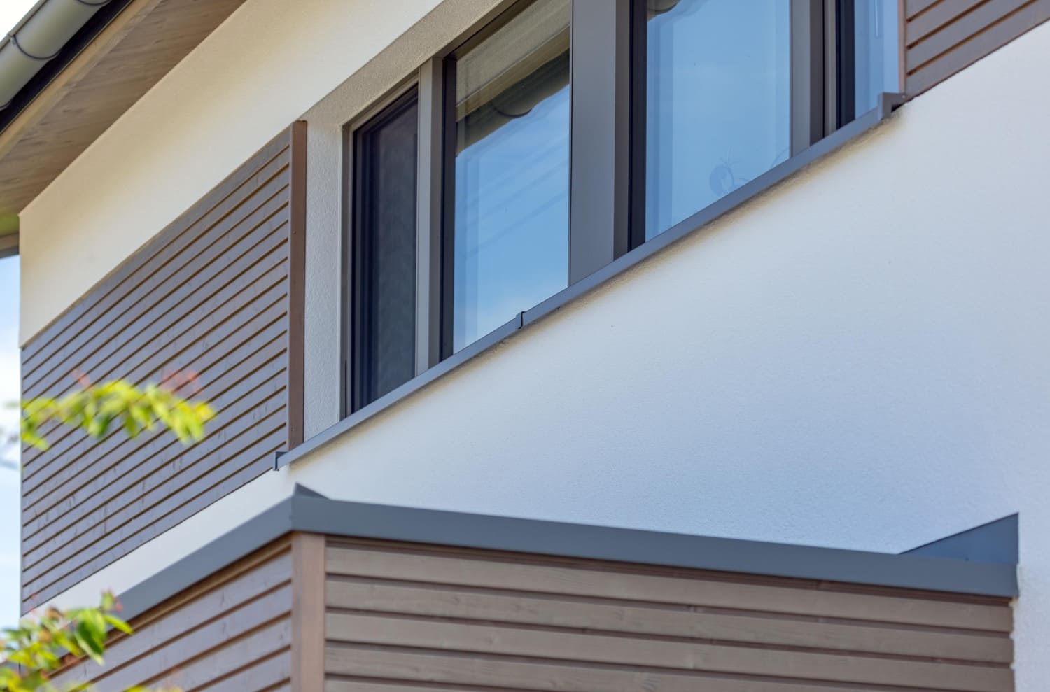 verputztes Holzhaus in Weilheim, hier Fenster im OG mit Holzfassadenelementen