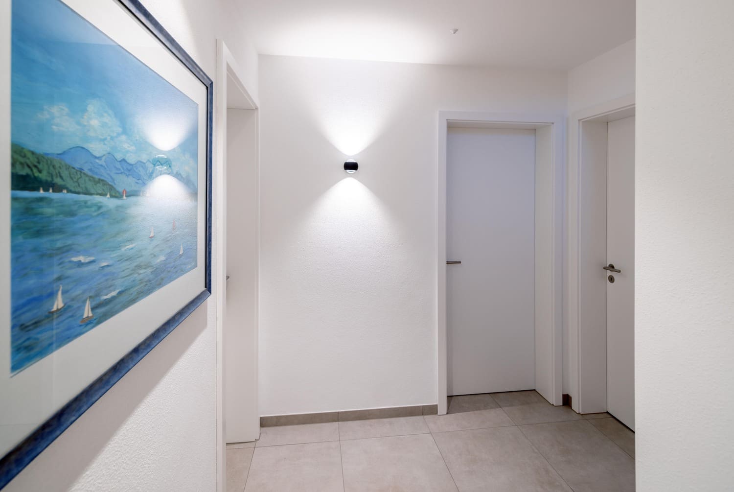 Holzhaus in Weilheim Kellerflur mit weißen Türen, Boden gefliest