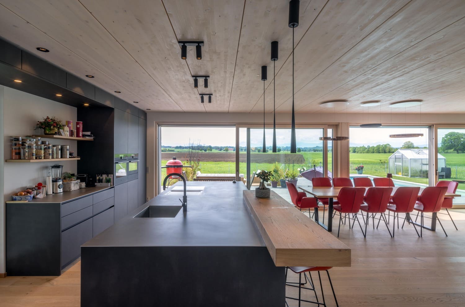 Holzhaus in Weilheim hier Küche mit Essbereich, große bodentiefe Fenster mit Gartenblick