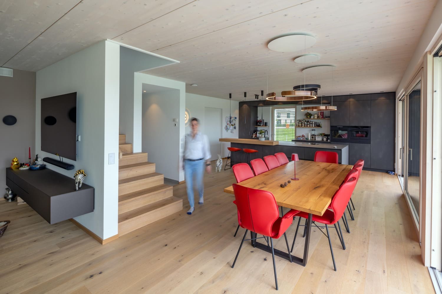 Holzhaus Weilheim Küche und Treppenzugang mit Bar und Esstisch, große Südfenster, Hebeschiebetür